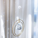 Attrape soleil cristal, à coté d'une fenêtre avec des arcs en ciel de lumière, DENADDA