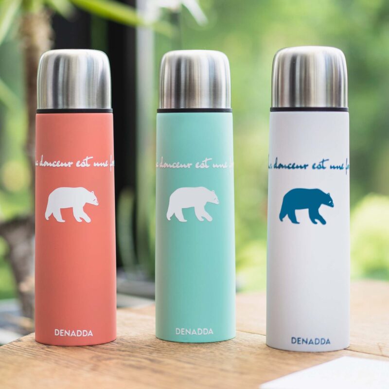 Thermos avec tasse intégrée - La souplesse est une force - L'ours KIKI soft touch Thermos avec tasse intégrée. Gourde de randonnée pour voyages dans différentes couleurs : orange, vert, blanc. La souplesse est une force avec l'ours KIKI de DENADDA